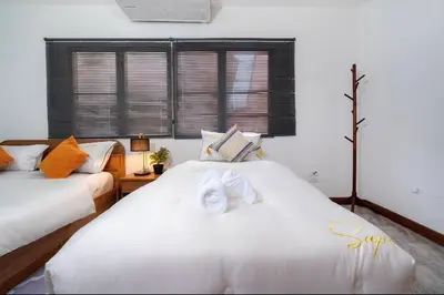 a bedroom with two beds and a window at Solene Home Patong in Patong Beach