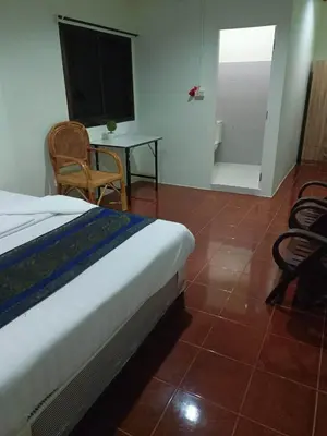 a bedroom with a bed and a table and chairs at Kata S.T House 2 in Phuket Town