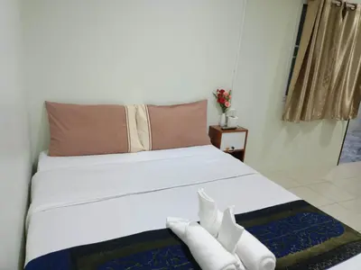 a bedroom with a bed with white shoes on it at Kata S.T House 2 in Phuket Town