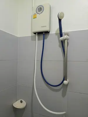 a shower with a blue hose attached to a wall at Kata S.T House 2 in Phuket Town