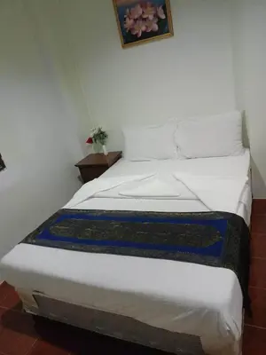 a bed with white sheets and a blue and white blanket at Kata S.T House 2 in Phuket Town
