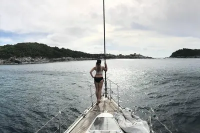 a woman standing on a boat in the water at 53ft Sailing Yacht PHUKET Family Sailing adventure in Bang Tao Beach