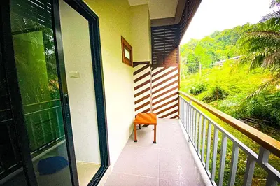 a balcony of a house with a chair on it at Chanpailin Omarzaa in Krabi town