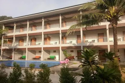 a hotel with a swimming pool and palm trees at Chanpailin Omarzaa in Krabi town