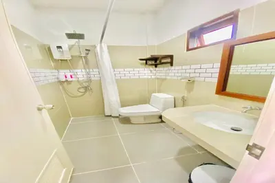 a bathroom with a toilet and a sink at Chanpailin Omarzaa in Krabi town