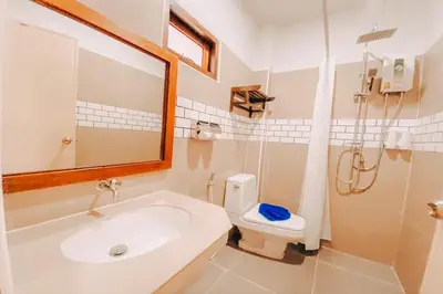 a bathroom with a sink and a toilet and a mirror at Chanpailin Omarzaa in Krabi town