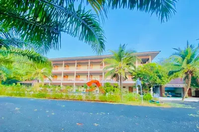 a hotel with palm trees in front of it at Chanpailin Omarzaa in Krabi town