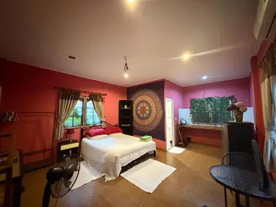 a bedroom with pink walls and a bed and a window at Mandala bungalow at Ya Nui beach in Rawai Beach