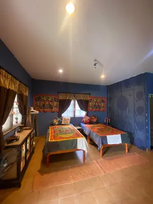 two beds in a room with blue walls at Elephant bungalow at Ya Nui beach in Phuket Town