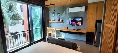a room with a table and a desk and a window at Relife The Windy in Phuket Town