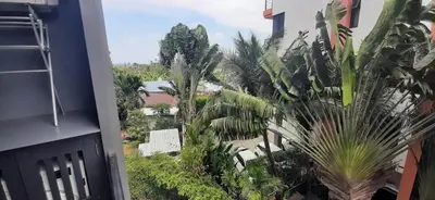 a view of a garden from a balcony with palm trees at Relife The Windy in Phuket Town