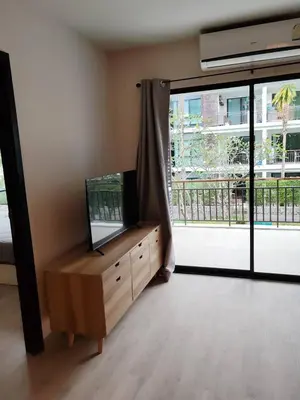 a living room with a tv and a large window at The Title Rawai Beach front 2BD in Rawai Beach