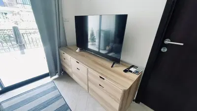 a television on a wooden dresser in a room at The Title Rawai Beach front 2BD in Rawai Beach