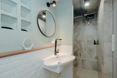 a white bathroom with a sink and a mirror at Dokdin's Family in Patong Beach