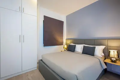 a bedroom with a white bed and a white cabinet at Utopia Naiharn in Nai Harn Beach