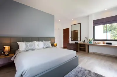 a bedroom with a large white bed and a mirror at Utopia Naiharn in Nai Harn Beach