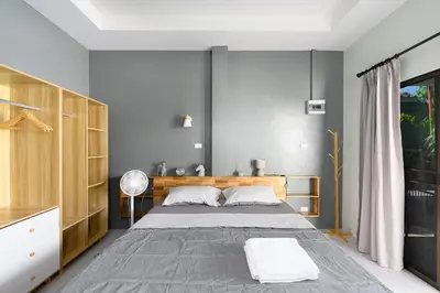 a bedroom with a large bed and a desk at Sansuko Ville Panwa in Ban Bo Rae