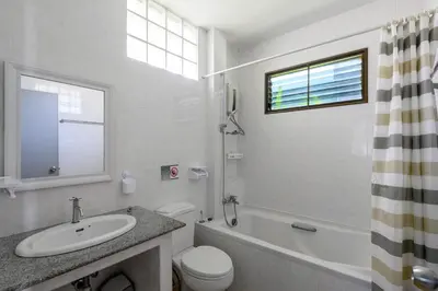 a white bathroom with a sink and a toilet at Sansuko Ville Panwa in Ban Bo Rae