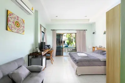 a bedroom with a bed and a desk and a couch at Sansuko Ville Panwa in Ban Bo Rae