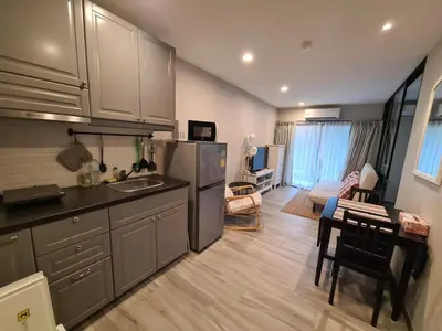 a kitchen with a stainless steel refrigerator and a living room at TITLE NaiYang apartment-300m from sea in Phuket Town