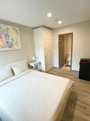 a bedroom with a large white bed and a bathroom at TITLE NaiYang apartment-300m from sea in Phuket Town