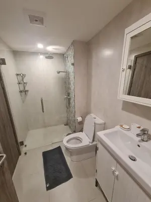 a bathroom with a toilet and a shower and a sink at TITLE NaiYang apartment-300m from sea in Phuket Town