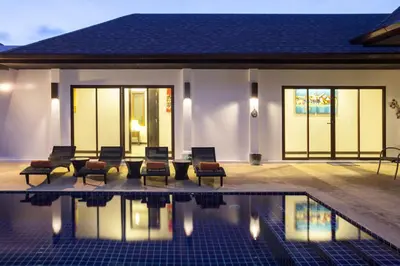 a house with chairs and a swimming pool at Exotic Boutique 4BR Pool Villa Toya, Gated Residence, Rawai in Rawai Beach