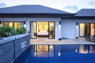 a villa with a swimming pool in front of a house at Exotic Boutique 4BR Pool Villa Toya, Gated Residence, Rawai in Rawai Beach