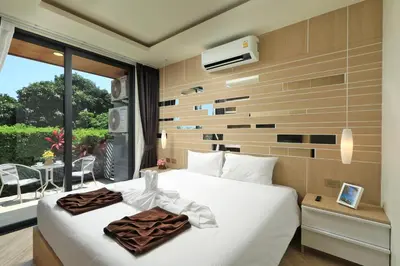 a hotel room with a bed and a balcony at Calypso Garden by Holy Cow, 1-BR, private terrace in Rawai Beach