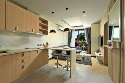 a kitchen with a table and a living room at Calypso Garden by Holy Cow, 1-BR, private terrace in Rawai Beach