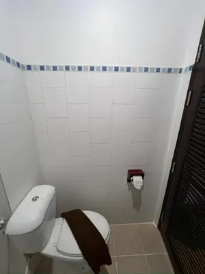 a bathroom with a toilet with a brown towel on it at Relax Guest House in Patong Beach