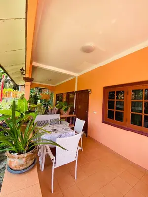 a patio with a table and chairs and a plant at Good vibes bungalow at Ya Nui beach in Phuket Town