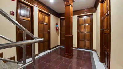 a hallway with wooden doors and stairs in a building at Lime Hotel in Patong Beach