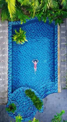 a person with an umbrella in a swimming pool at Kraam Silhouette Hotel and Cafe Phuket- Chalong pier Hotel in Chalong
