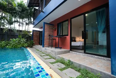 a house with a swimming pool next to a house at Kraam Silhouette Hotel and Cafe Phuket- Chalong pier Hotel in Chalong