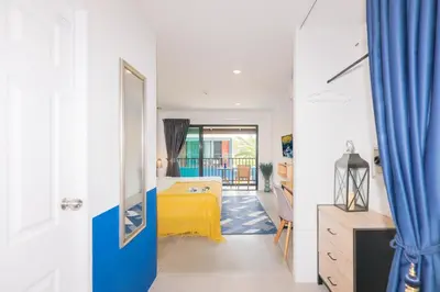 a bedroom with a yellow bed in a room at Kraam Silhouette Hotel and Cafe Phuket- Chalong pier Hotel in Chalong