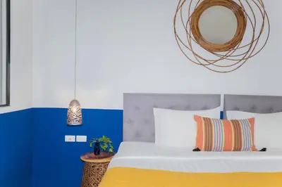 a bedroom with a bed and a mirror at Kraam Silhouette Hotel and Cafe Phuket- Chalong pier Hotel in Chalong