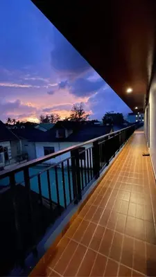 a balcony of a building with a sunset in the background at Twenty Two House in Patong Beach
