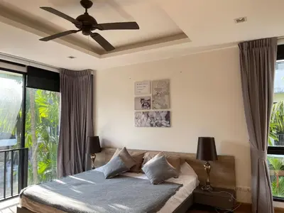 a bedroom with a bed and a ceiling fan at Нескучный таунхаус в Лагуне in Phuket Town