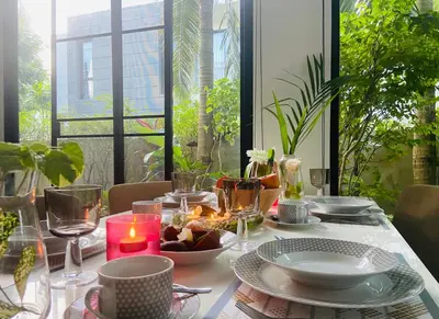 a table with candles and plates and a candle holder on it at Нескучный таунхаус в Лагуне in Phuket Town