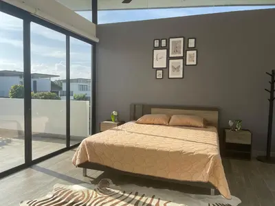 a bedroom with a bed and a large window at Нескучный таунхаус в Лагуне in Phuket Town