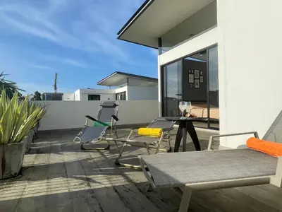 a patio with a table and chairs on a roof at Нескучный таунхаус в Лагуне in Phuket Town