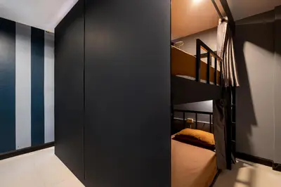 a room with two bunk beds and a black wall at Black Pantera Hostel in Patong Beach