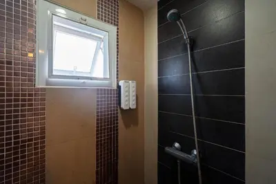 a bathroom with a shower and a window at Black Pantera Hostel in Patong Beach