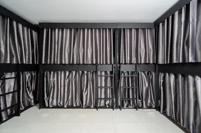 a room with black and gray curtains and a white tile floor at Black Pantera Hostel in Patong Beach