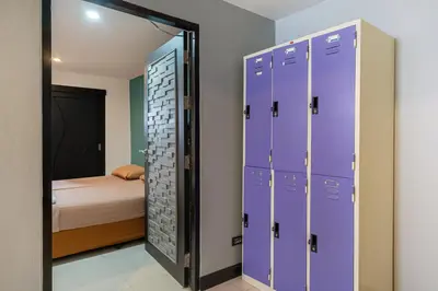 a locker room with purple lockers and a bed at Black Pantera Hostel in Patong Beach