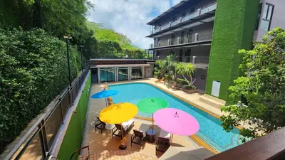 an overhead view of a swimming pool with umbrellas at Alaita Boutique Phuket in Ban Bo Rae