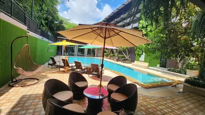 a pool with chairs and a table with shoes on it at Alaita Boutique Phuket in Ban Bo Rae