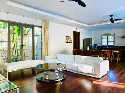 a living room with a white couch and a table at Luxe 2br Pool Villa walk to Bangtao Beach in Ban Thalat Choeng Thale
