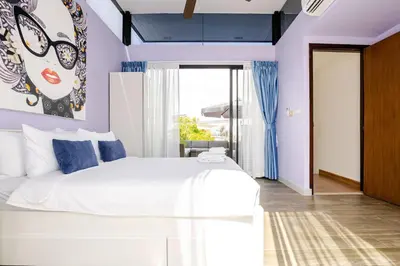 a bedroom with a white bed with blue accents at LP 65-57 Spacious holiday home close to the beach in Phuket Town